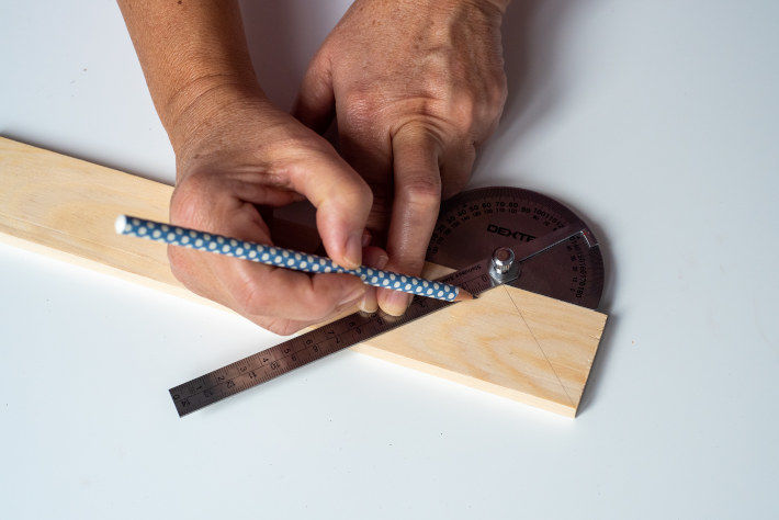 Odrysowywanie ołówkiem na drewnianej listwie kształtów do wycięcia